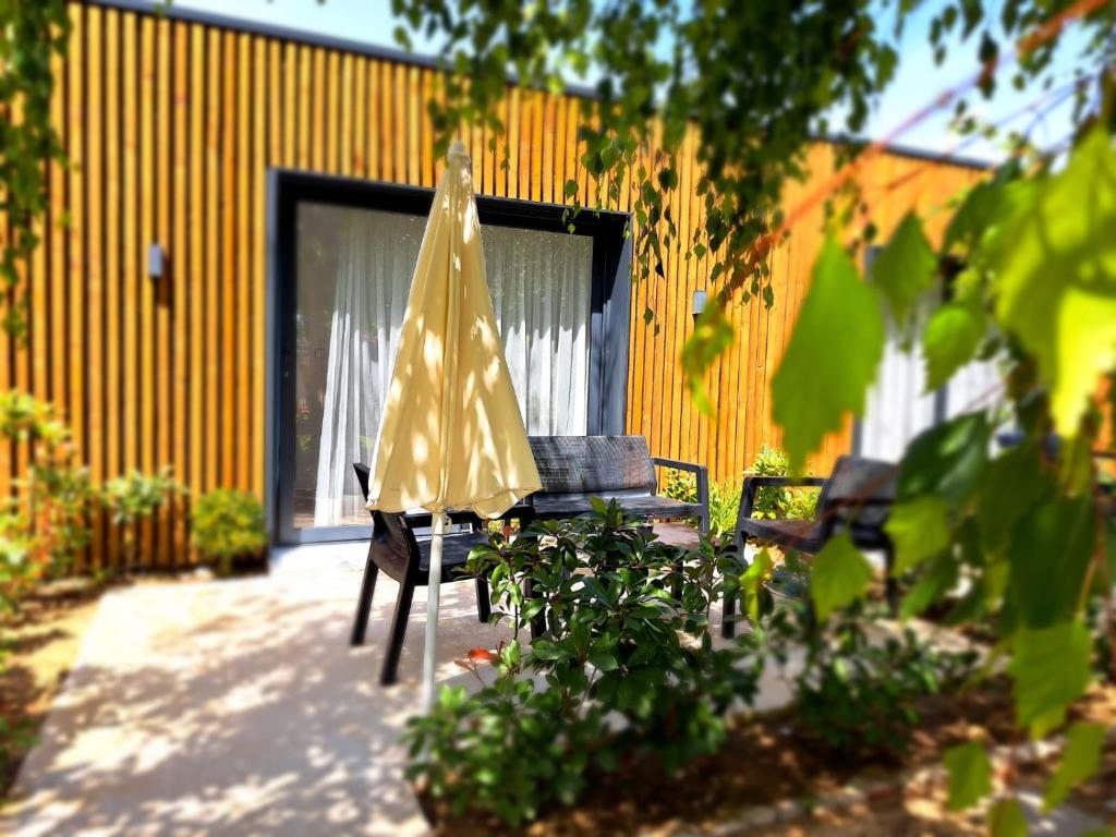 a yellow umbrella sitting next to a chair and a table at Garden Apartments in Ulcinj