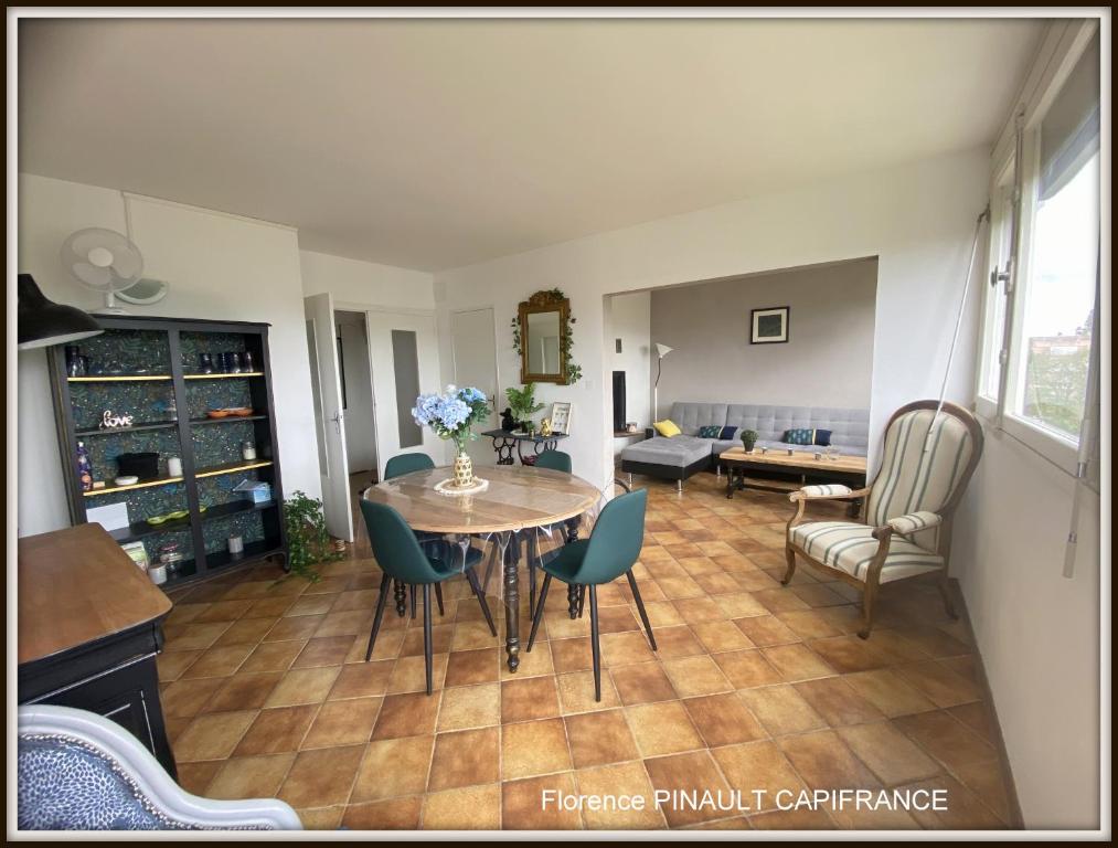 a living room with a table and chairs at Apparemment tout confort in Tarbes