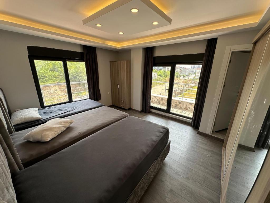Schlafzimmer mit einem großen Bett und großen Fenstern in der Unterkunft YUNUSELİ 7+2 VİLLA LUXURY in Yunuseli