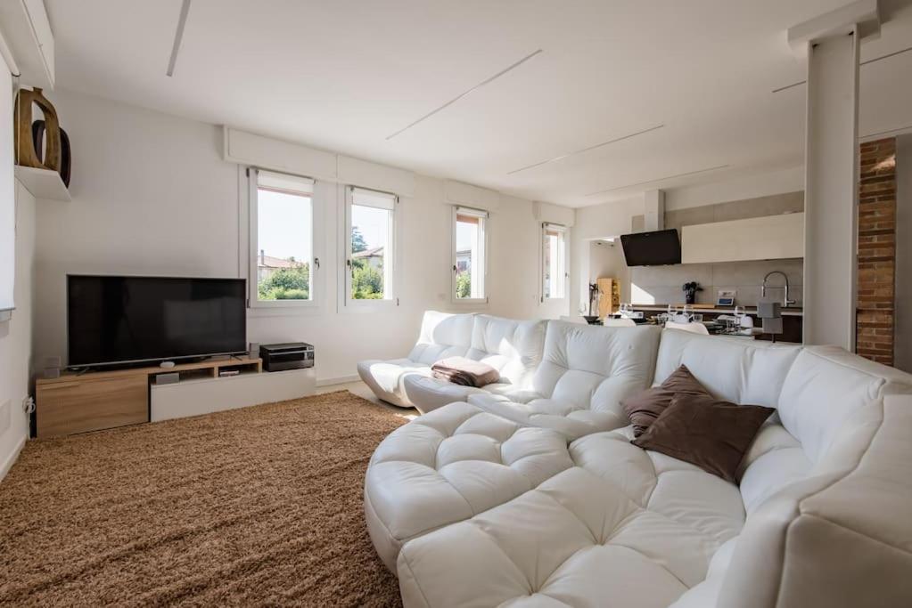a living room with a white couch and a television at Apartment deluxe ground floor Venice/Treviso park in Silea