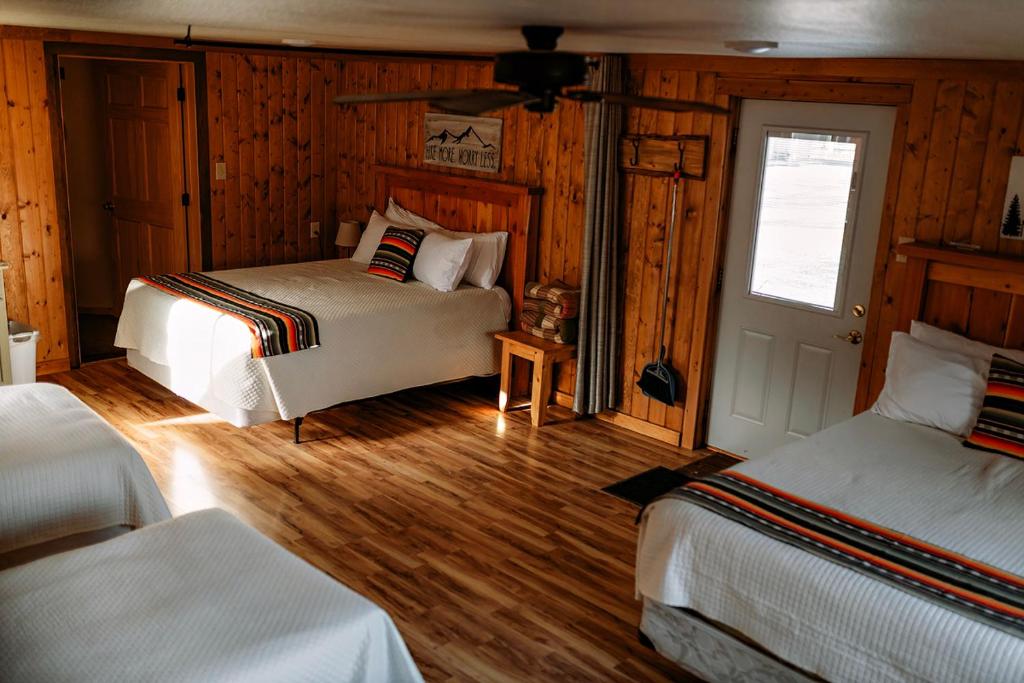 2 camas en una habitación con paredes de madera en Shell Campground en Shell