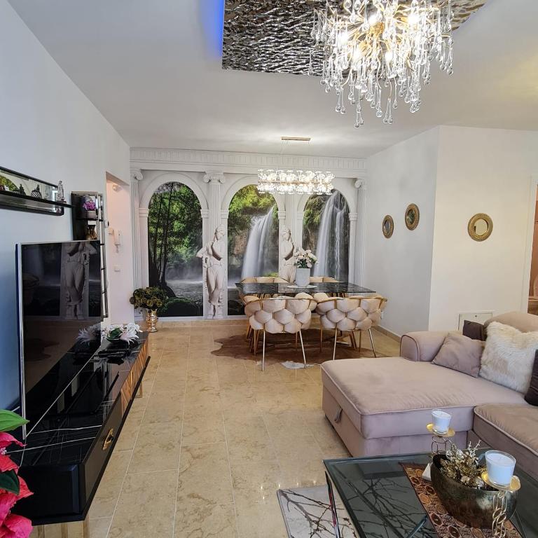 a living room with a couch and a chandelier at CRISTINCO PANORAMIC in Cluj-Napoca