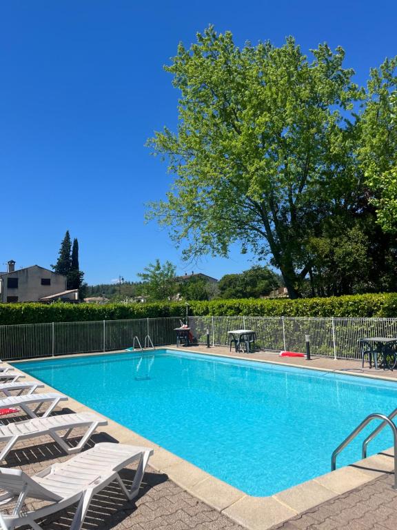 einen Pool mit Stühlen und einem Baum in der Unterkunft Hôtel Restaurant Douce France in Saint Alban Auriolles
