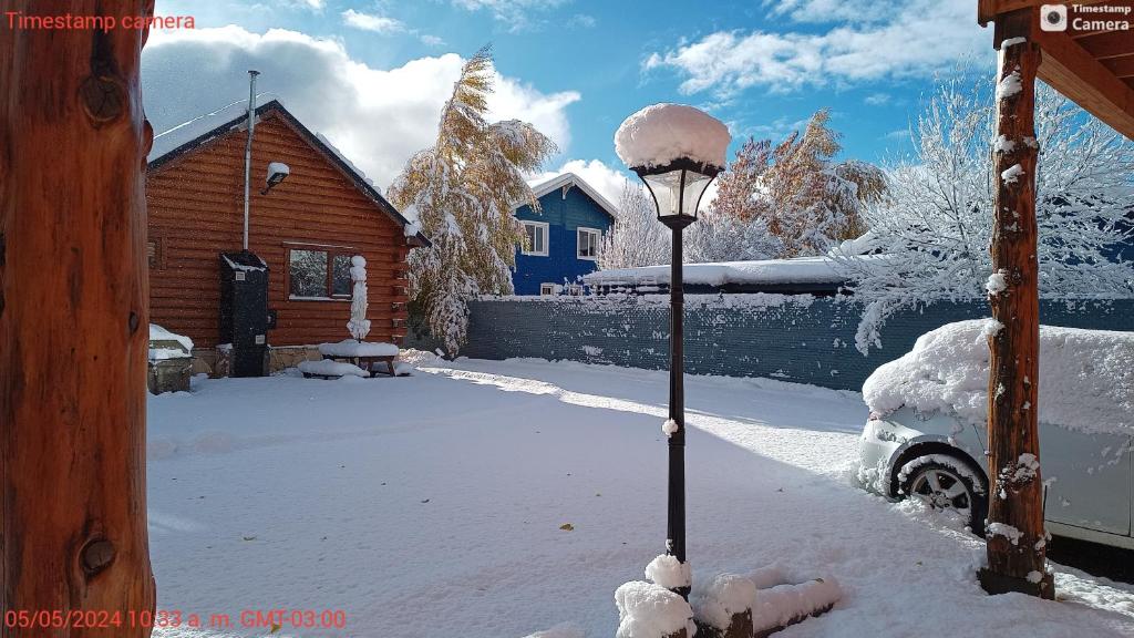 a street light covered in snow next to a house at Alojamiento Ruca Wenüy dpto 03 in San Carlos de Bariloche