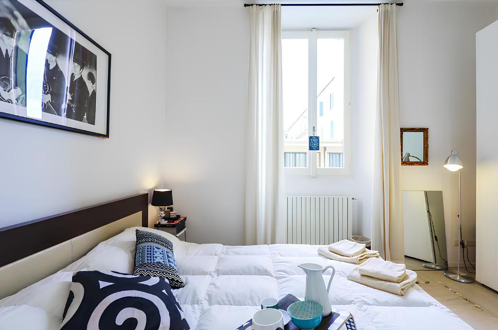 Cama blanca en habitación con ventana en DESIGN DISTRICT - Milan Apartment, en Milán