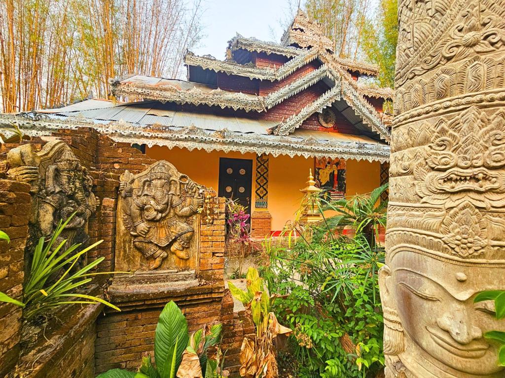 Un edificio con una statua davanti di Phu Jaya Floresta Resort by ALPHATEL a Chiang Mai