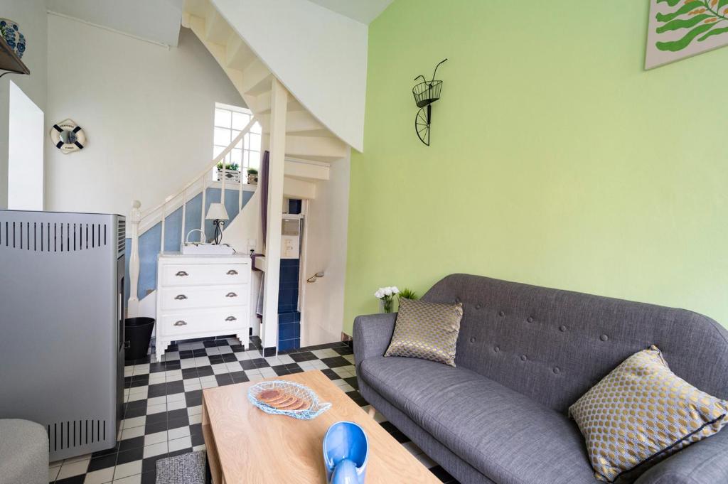een woonkamer met een bank en een tafel bij Escapade au Roc de Picchu in Étretat