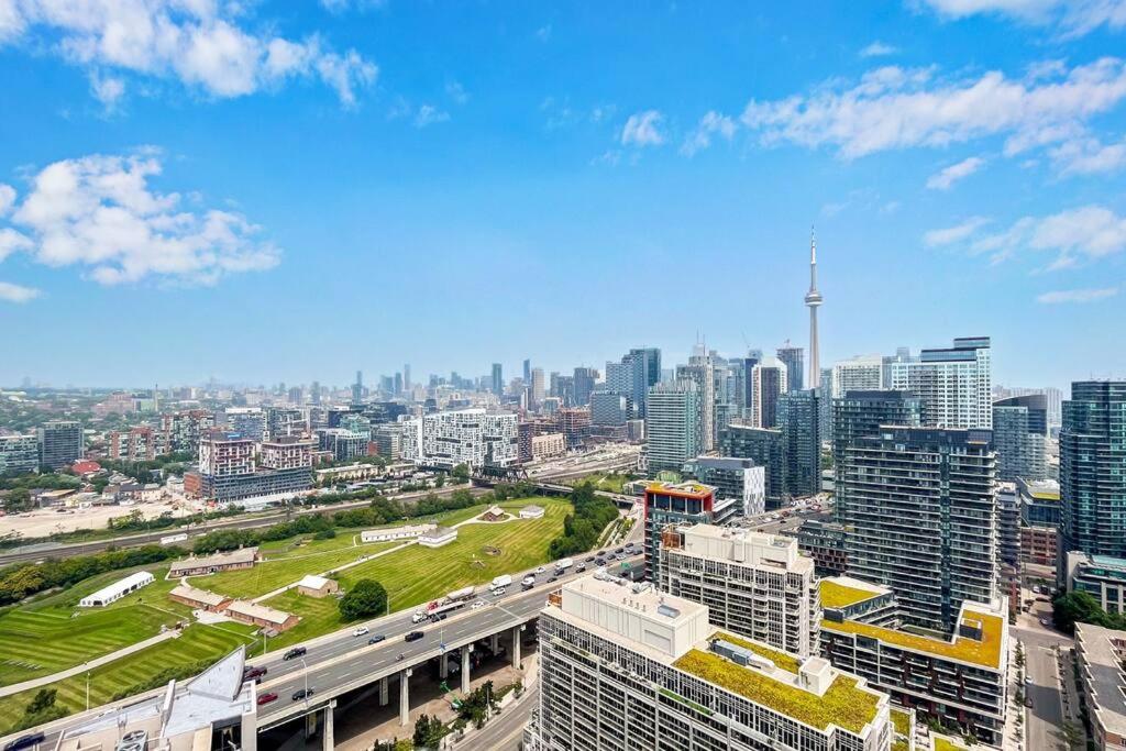 2 BR with Amazing city views, Free parking and pool في تورونتو: اطلالة جوية على مدينة بها مباني وطريق سريع