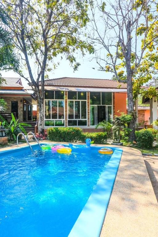 a swimming pool in front of a house at Phalaburi resort by dreamhouse in Ban Phala