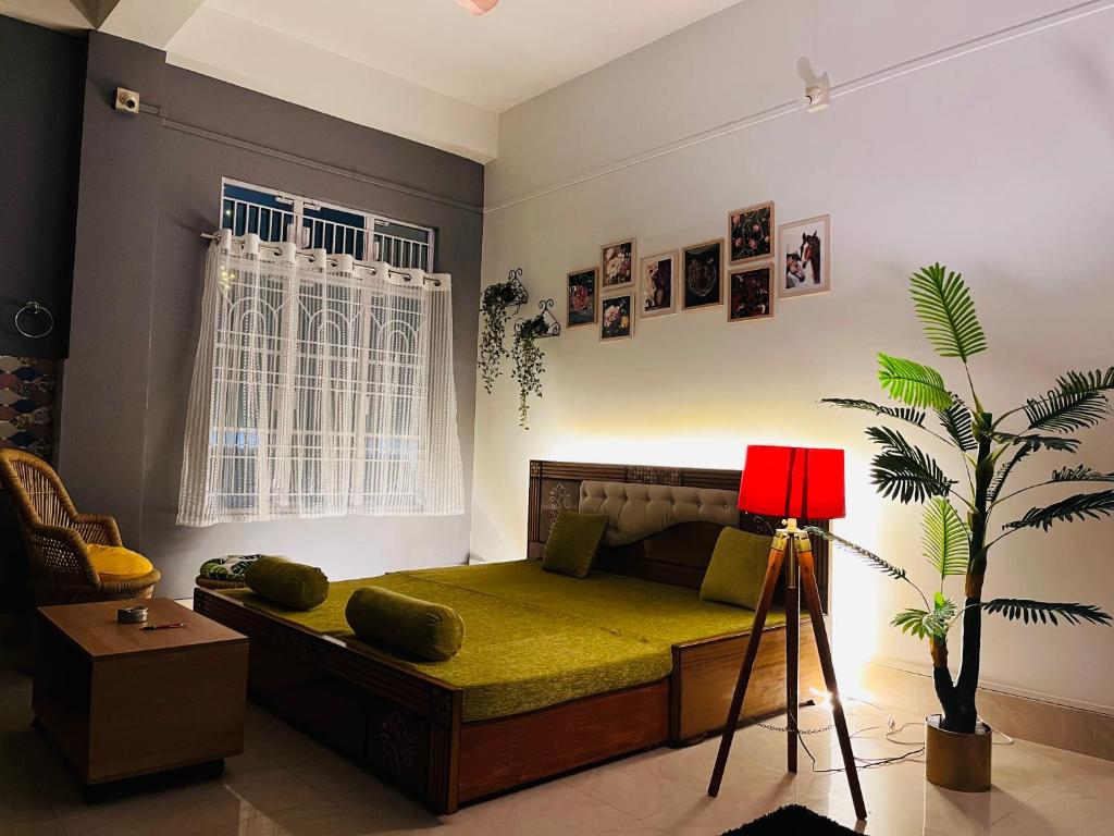 a bedroom with a bed and a plant in it at Ujoni Homestay in Duliajan in Duliāgaon