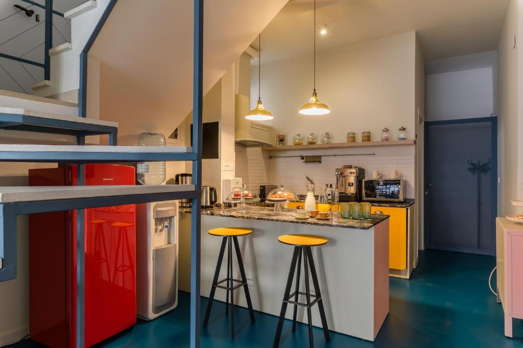 a kitchen with yellow and red stools at Unico B&B Art Decor in Ostuni