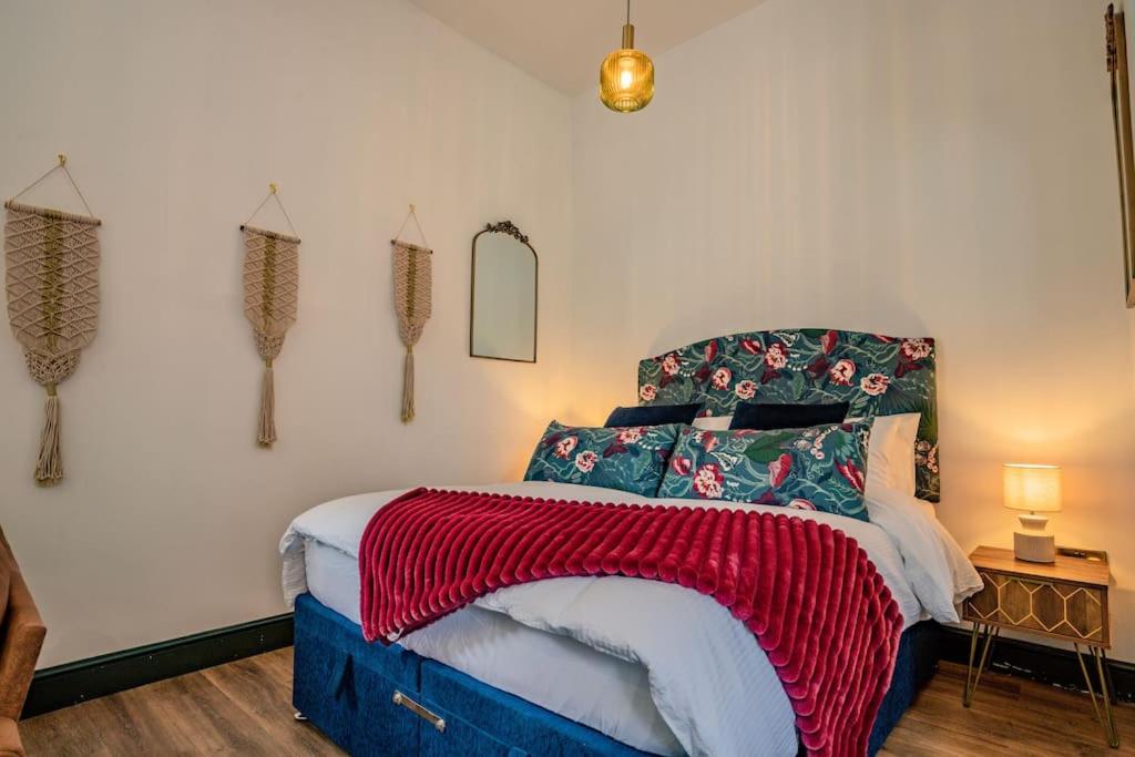 - une chambre avec un lit et une couverture rouge dans l'établissement Guest Homes - Foregate Studio Apartment, à Worcester