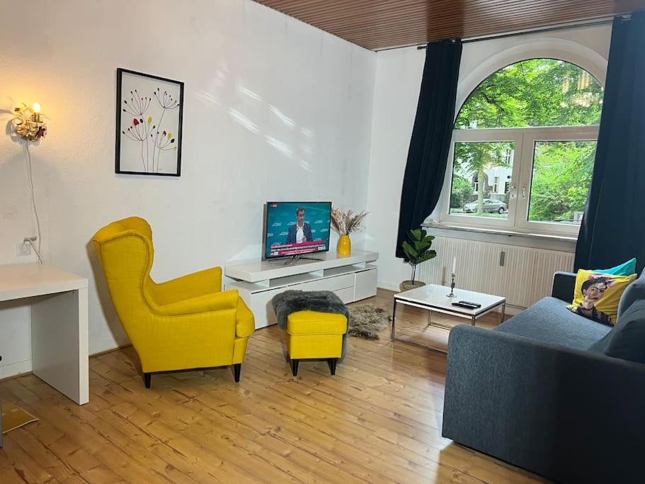 a living room with a couch and yellow chairs at Casa Luna 6 min Hbf , Erdgeschosswohnung ,Altbau in Duisburg