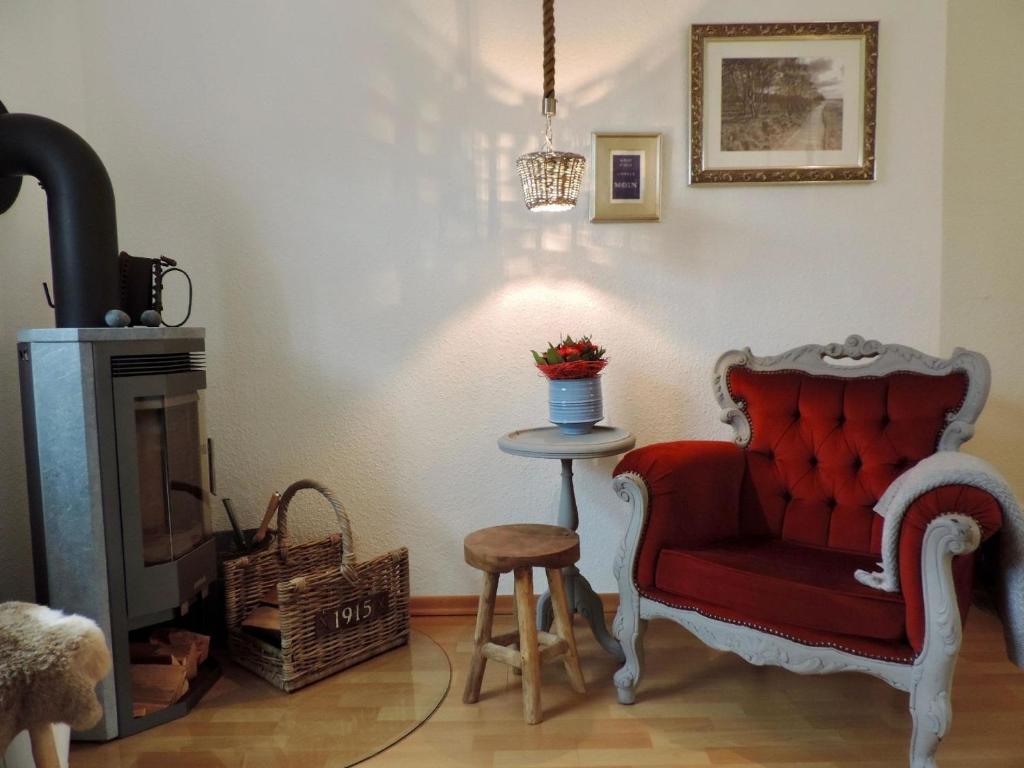 uma sala de estar com uma cadeira vermelha e uma mesa em Ferienhaus in Blandorf-Wichte mit Garten und Terrasse em Hage