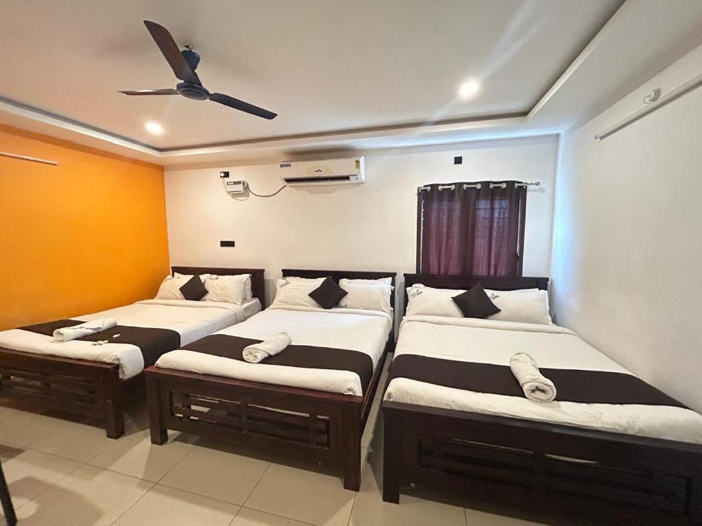 três camas num quarto com tecto em The Ocean Edge em Pondicherry