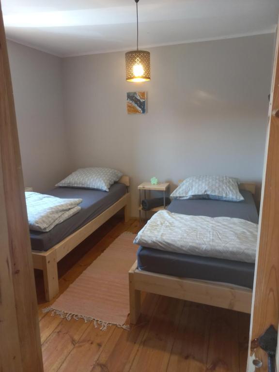 a bedroom with two beds and a light fixture at Na Rogu in Lębork