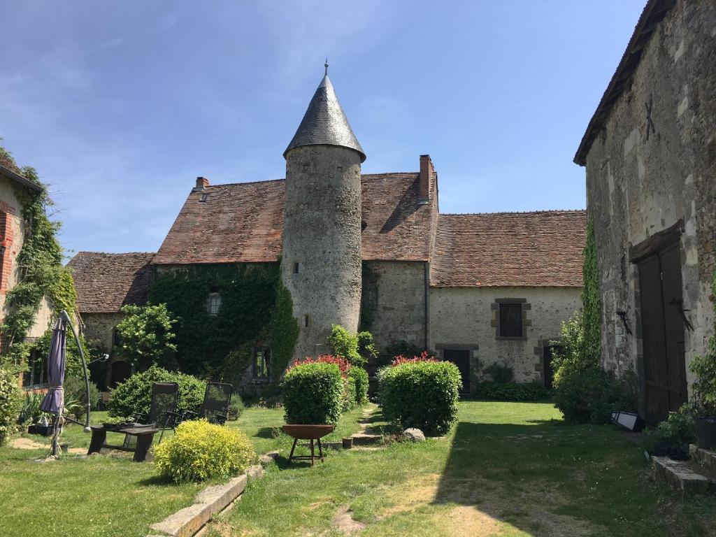 an old building with a tower in a yard at Chateau Mareuil in Brigueuil-le-Chantre