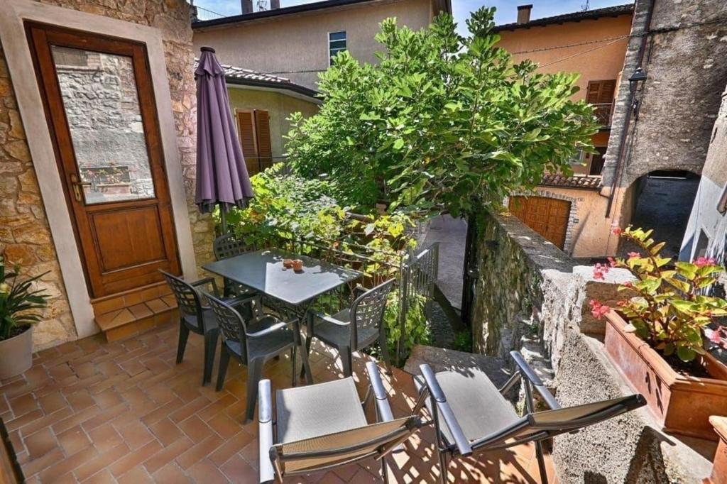 eine Terrasse mit einem Tisch und Stühlen auf dem Balkon in der Unterkunft Apartment Fico in Tignale