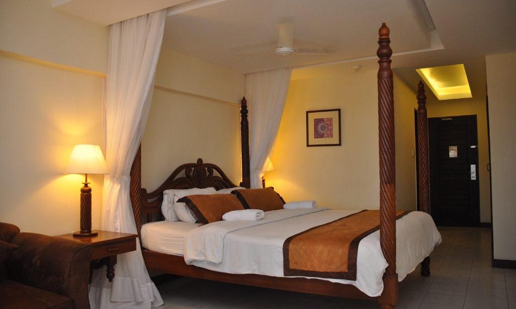 a bedroom with a large bed with a canopy at Royal Court Hotel in Mombasa