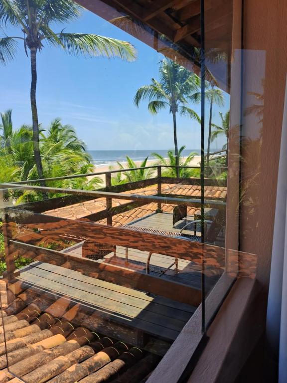a room with a view of the beach and palm trees at Casa Del Mar in Marau