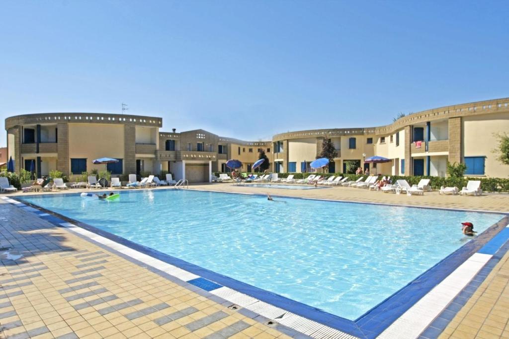 einem großen Pool vor einem Gebäude in der Unterkunft Wohnungen in Ferienanlage in Bibione