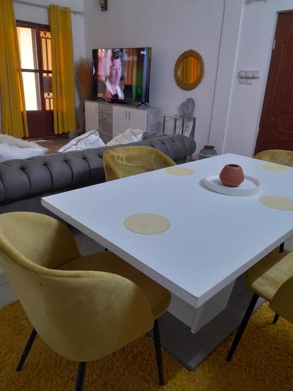 een woonkamer met een witte tafel en stoelen bij Mienmo Residence in Ouagadougou