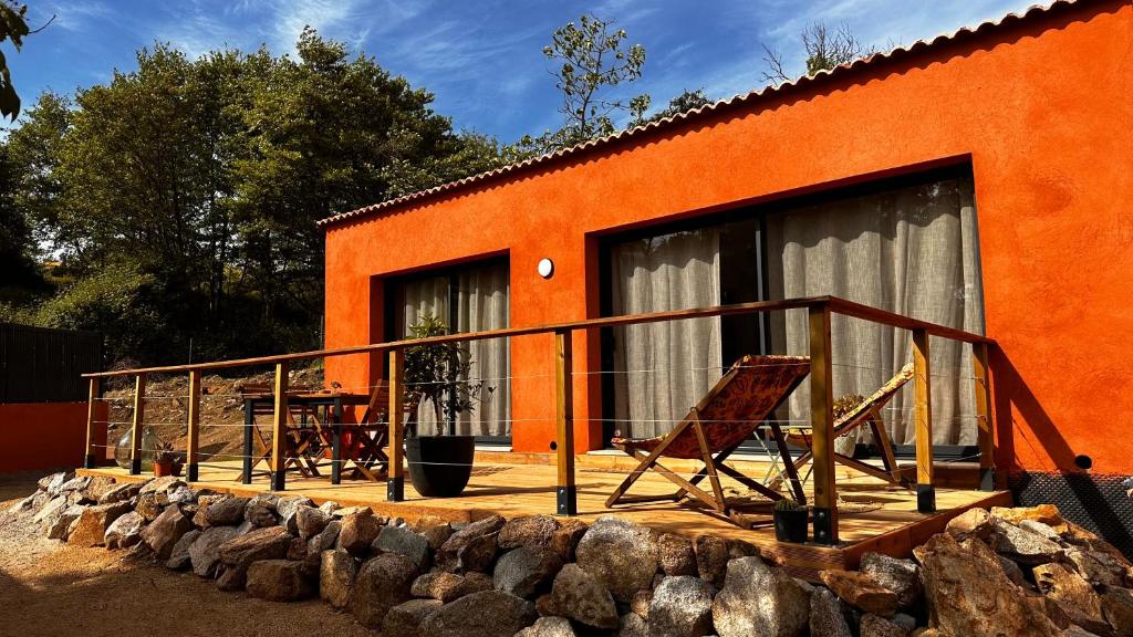 an orange house with a deck with a table and chairs at Maison 47m2 à 10min des plages - billard, baby, salle de sport, jardin in Ajaccio