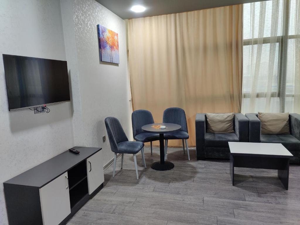 ein Wohnzimmer mit einem Sofa, einem Tisch und Stühlen in der Unterkunft SECRET HOTEL in Baku