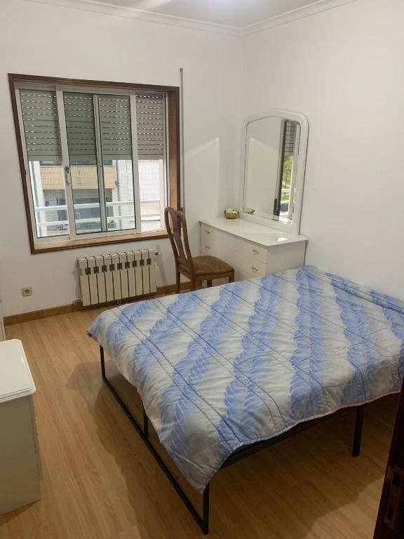 a bedroom with a bed and a dresser and a mirror at Xxxxxxxxxx in Bragança