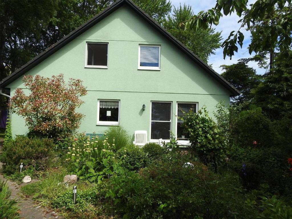 ein grünes Haus mit Fenstern im Garten in der Unterkunft Ferienwohnung Ostseestern für 4 Personen in Wiek auf Rügen 