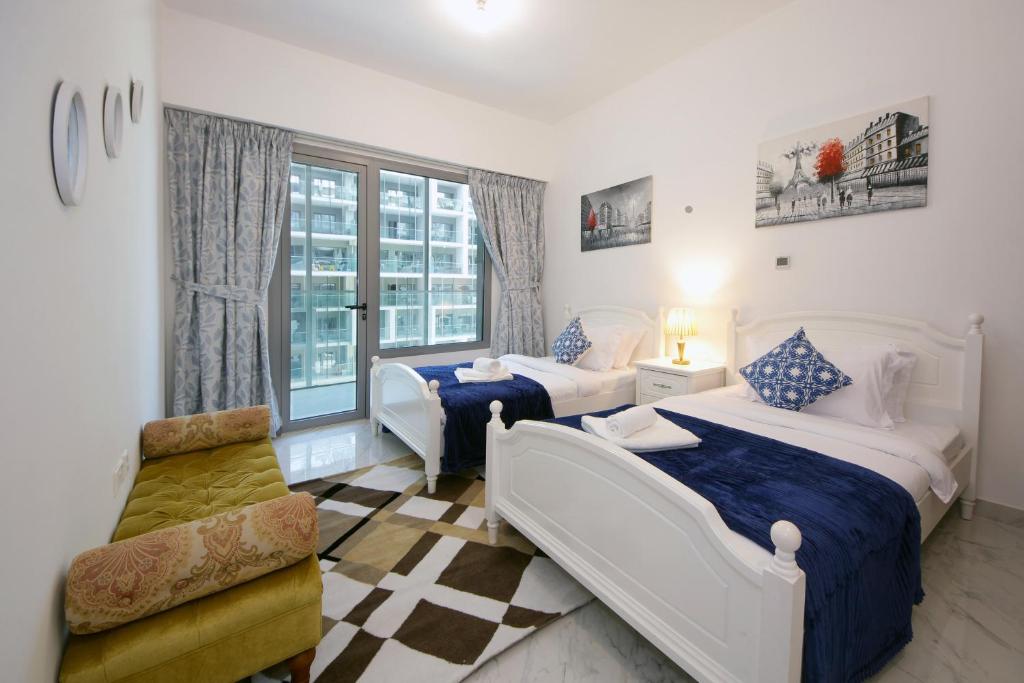 una camera d'albergo con due letti e una sedia di Silk Valley - Furnished Luxury 1bhk Pool & Gym a Abu Dhabi