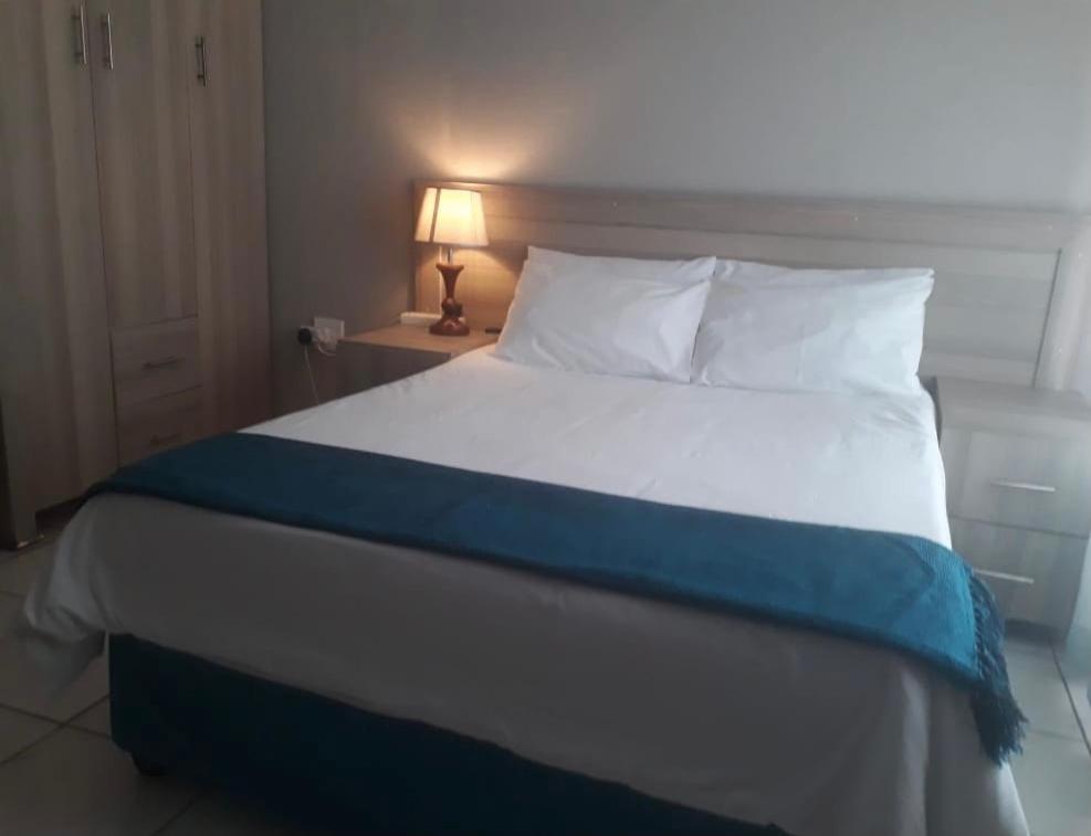 a bedroom with a bed with a blue and white blanket at Rethabile Guesthouse in Bochum