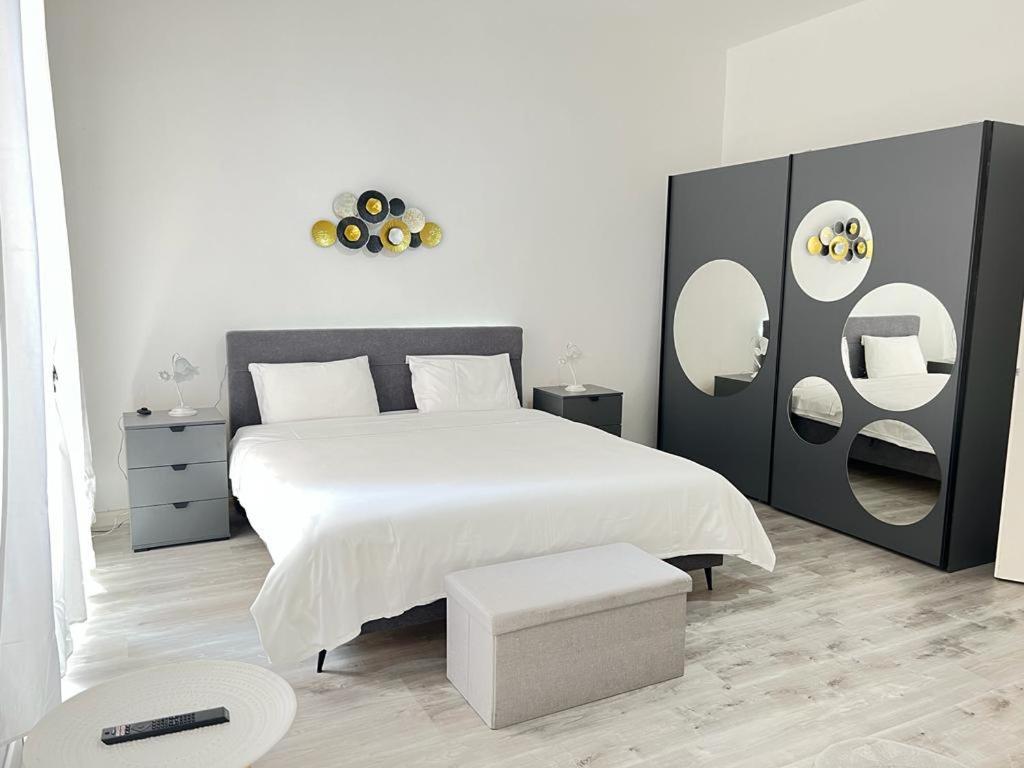 een slaapkamer met een groot wit bed met spiegels aan de muur bij B&B Ilien in Bellinzona