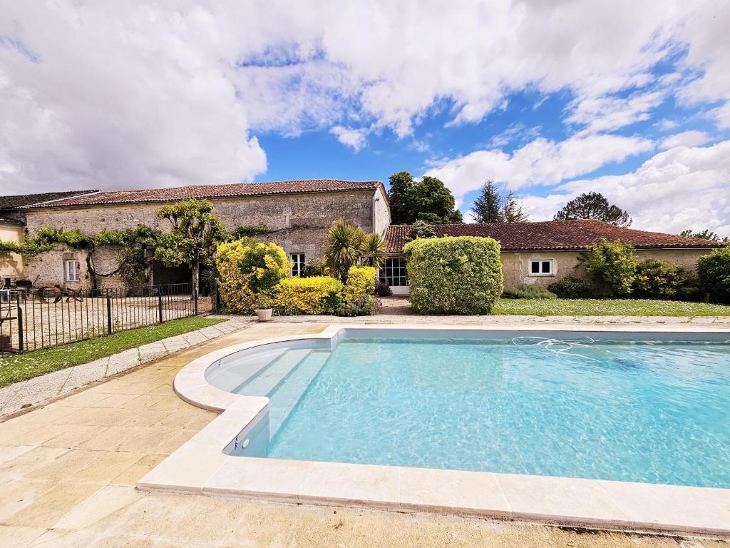 une piscine devant une maison dans l'établissement L échappée belle en campagne charentaise, à Gondeville