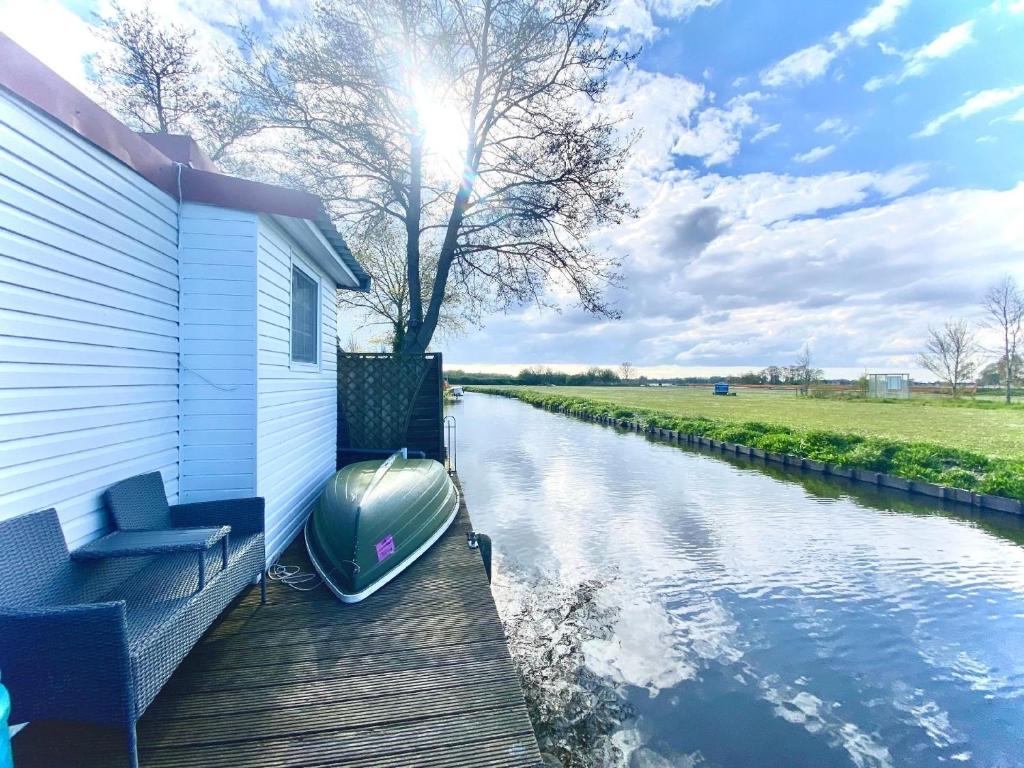 a boat sitting on a dock next to a house at Nettes Ferienhaus in Wervershoof mit Terrasse, Garten und Grill in Wervershoof