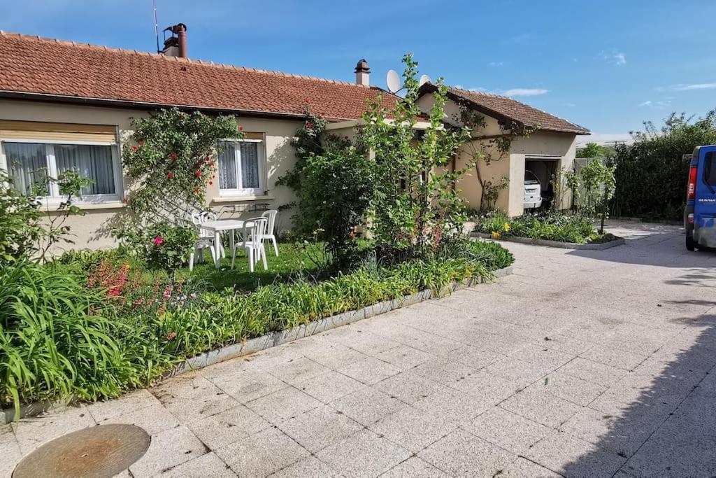 une maison avec une table et des chaises dans la cour dans l'établissement Plain pied calme parking privé 5 lits 1 lit bébé proximité Metz, à Woippy