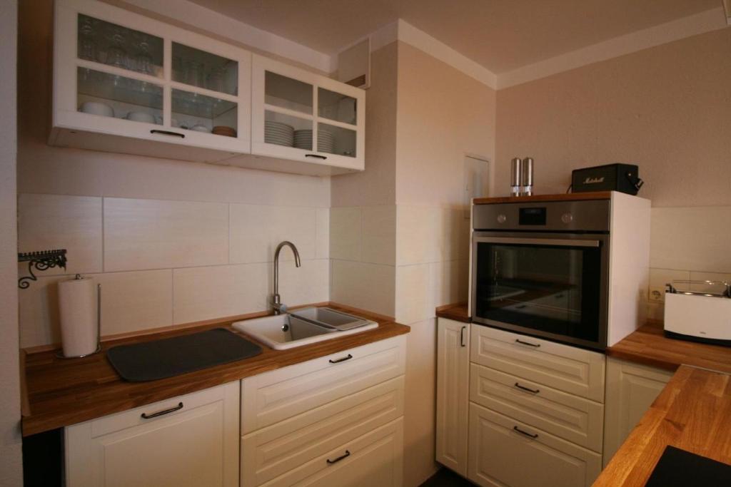 a kitchen with white cabinets and a sink at Tolle Ferienwohnung in Schönberger Strand in Schönberger Strand