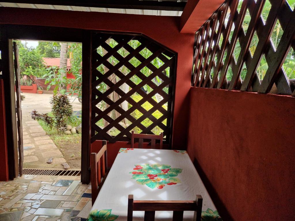 - une table et des chaises dans une pièce avec porte dans l'établissement Bungalow chez Mouch Nosy-Be 2, à Nosy Be