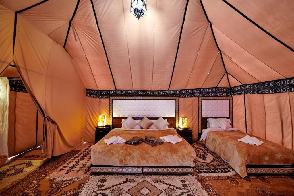 1 dormitorio con 2 camas en una tienda de campaña en riad luz merzouga en Merzouga