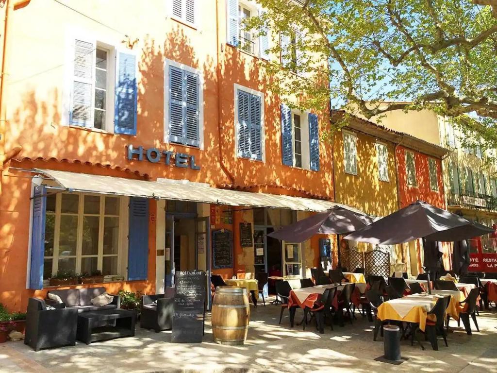 un restaurant avec des tables et des chaises devant un bâtiment dans l'établissement Wangberg Provence, à Villecroze