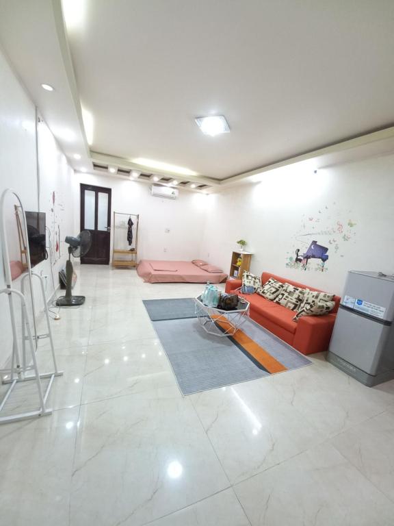 a living room with a red couch and a table at HAPPY HOMESTAY Đình Đông in Hai Phong