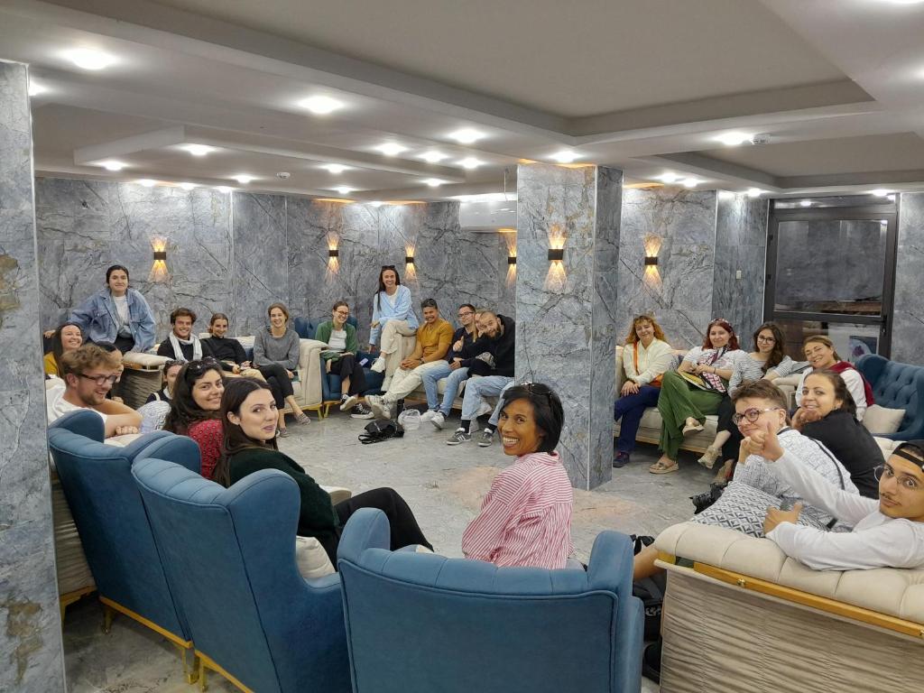 un grupo de personas sentadas en sillas en una habitación en Beirut Hotel 2 New, en Amán