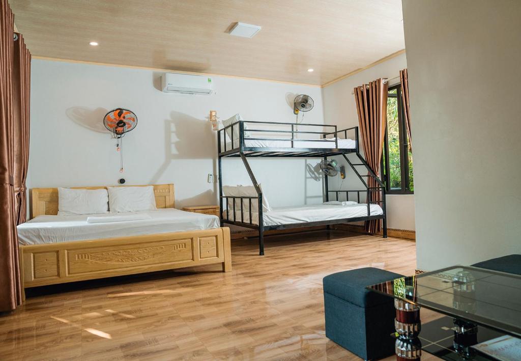 a bedroom with two bunk beds and a couch at Tran Chau Garden Home in Cat Ba