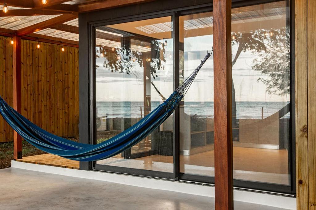 a hammock is hanging in a room with windows at Tiny Homes Venao Cove in Playa Venao
