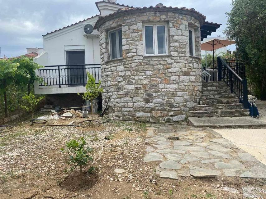 a stone house with a porch and a balcony at Villa Reni in Limenaria