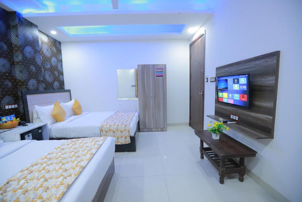 Cette chambre comprend 2 lits et une télévision à écran plat. dans l'établissement Hotel Triton Grand At Delhi Airport, à New Delhi