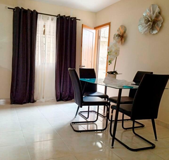 comedor con mesa de cristal y sillas en Lujoso apartamento completo, en Mendoza