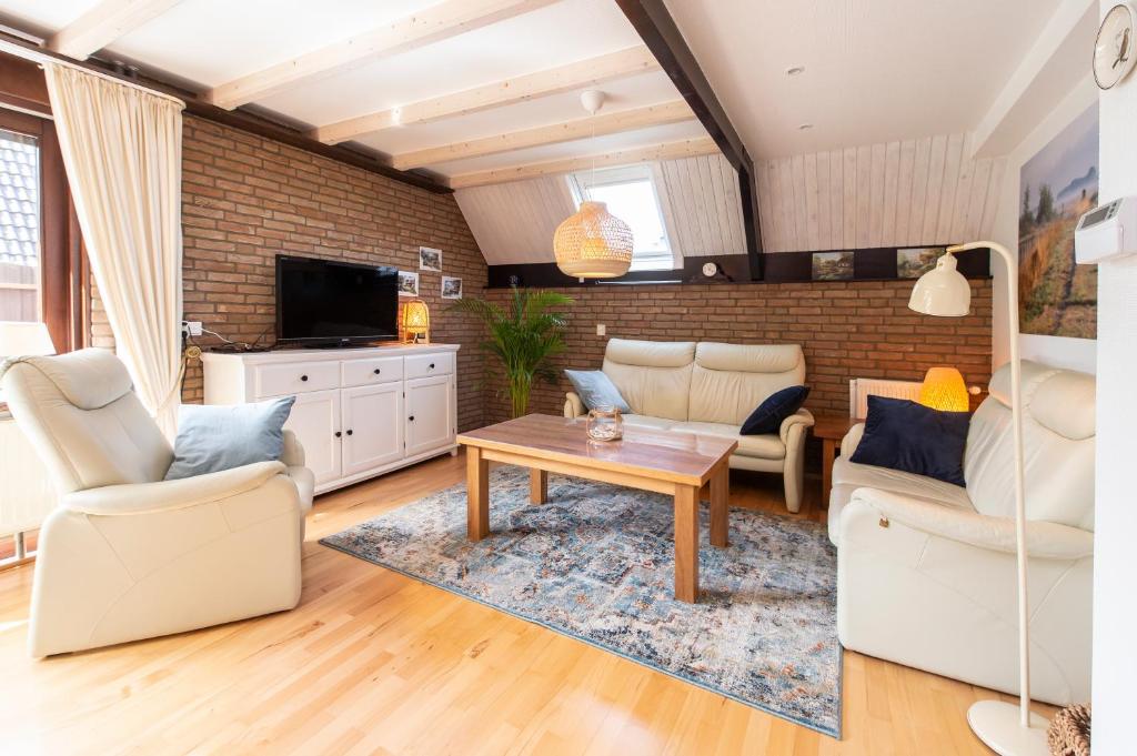 sala de estar con 2 sillas y mesa en Luxe 4p huis met SAUNA bij Grevelingenmeer!, en Herkingen