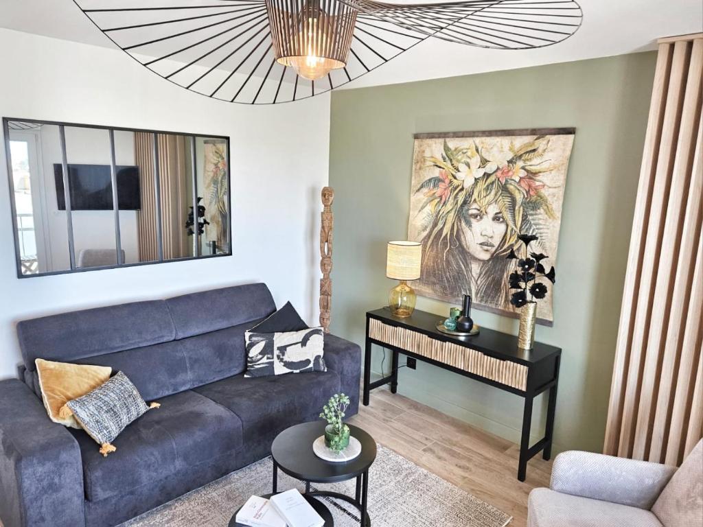 un salon avec un canapé bleu et une table dans l'établissement T2 design proche gare/Intra-M/Sillon, garage privé, à Saint-Malo