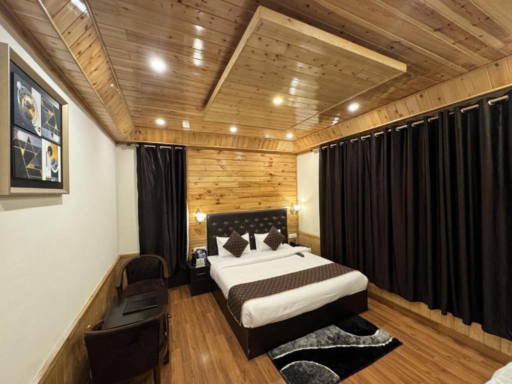 1 dormitorio con 1 cama en una habitación con paredes de madera en Hotel Black Magic en Manāli